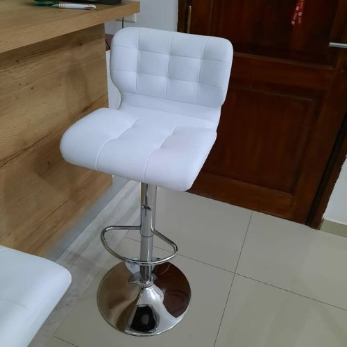 Banqueta regulable en altura, giratoria 360°, estructura cromada y asiento en ecocuero acolchonado estilo capitone